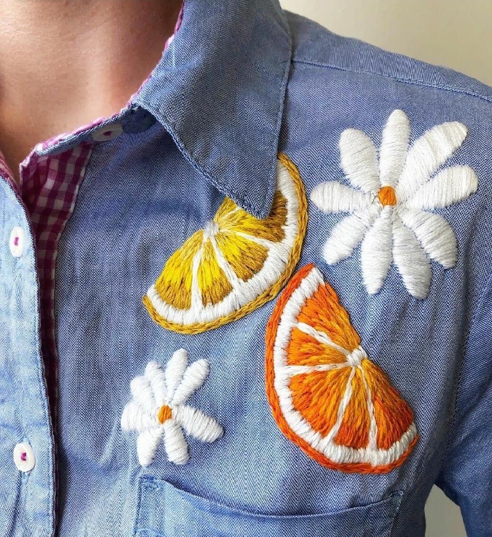 Camicia ricamata con fiori e frutta.